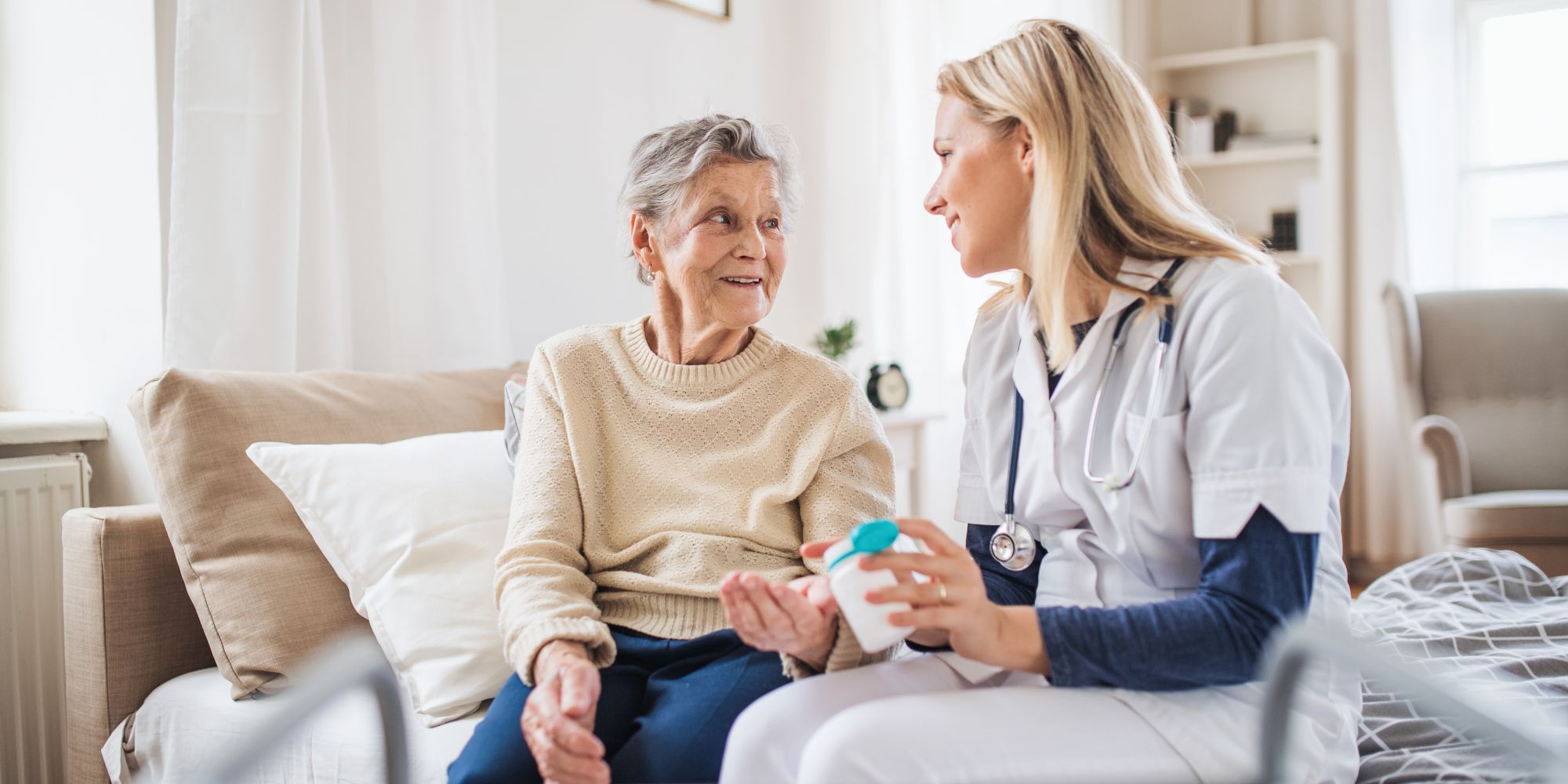 Eine Pflegekraft unterstützt eine ältere Dame