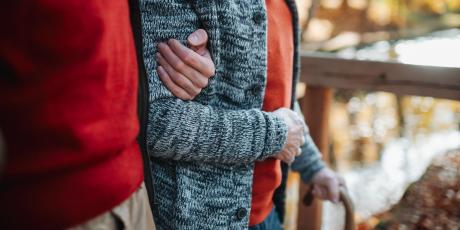 Junger Mann stützt älteren Mann beim Gehen