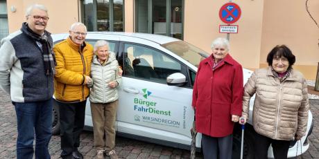 Personen vor einem Auto